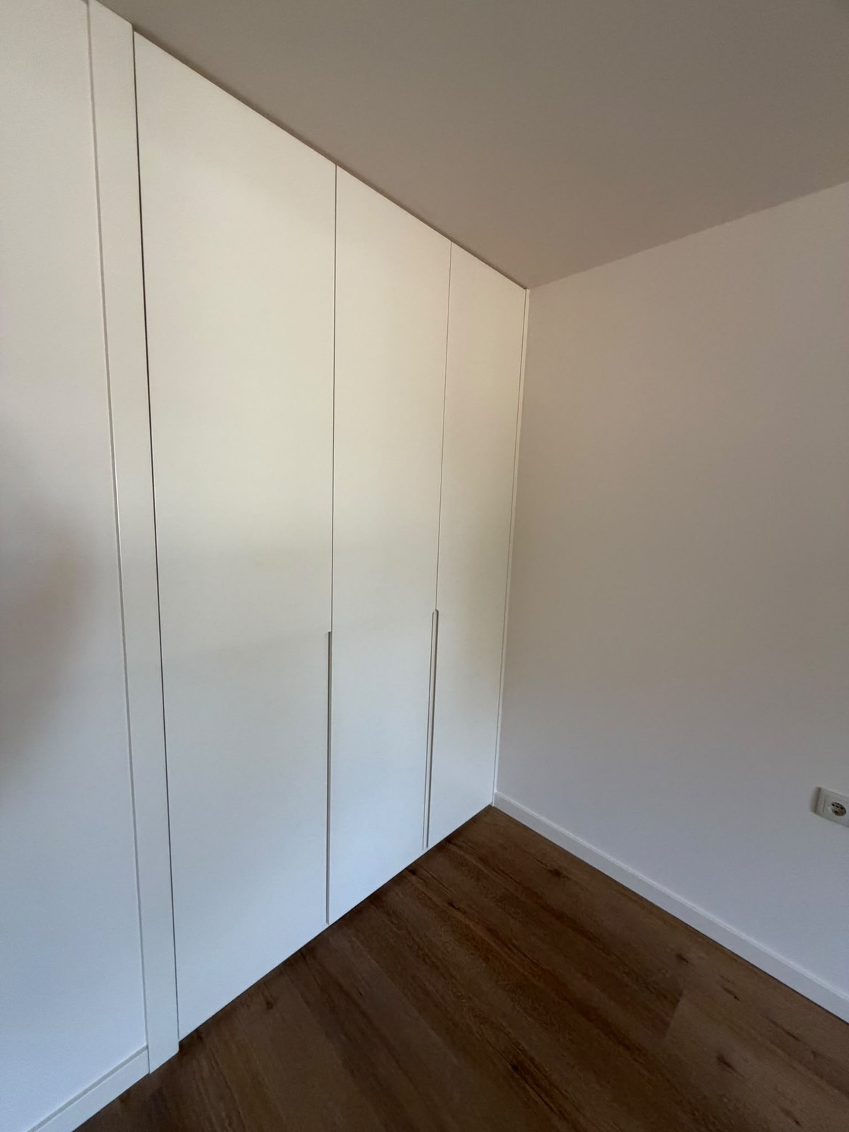Roupeiro branco do chão ao teto com portas de abrir